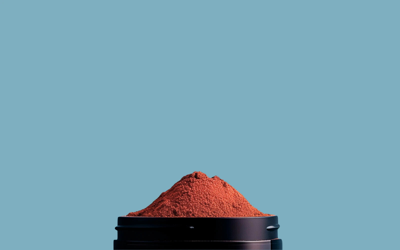 Image d'un mélange d'épices dans un pot noir avec un fond bleu