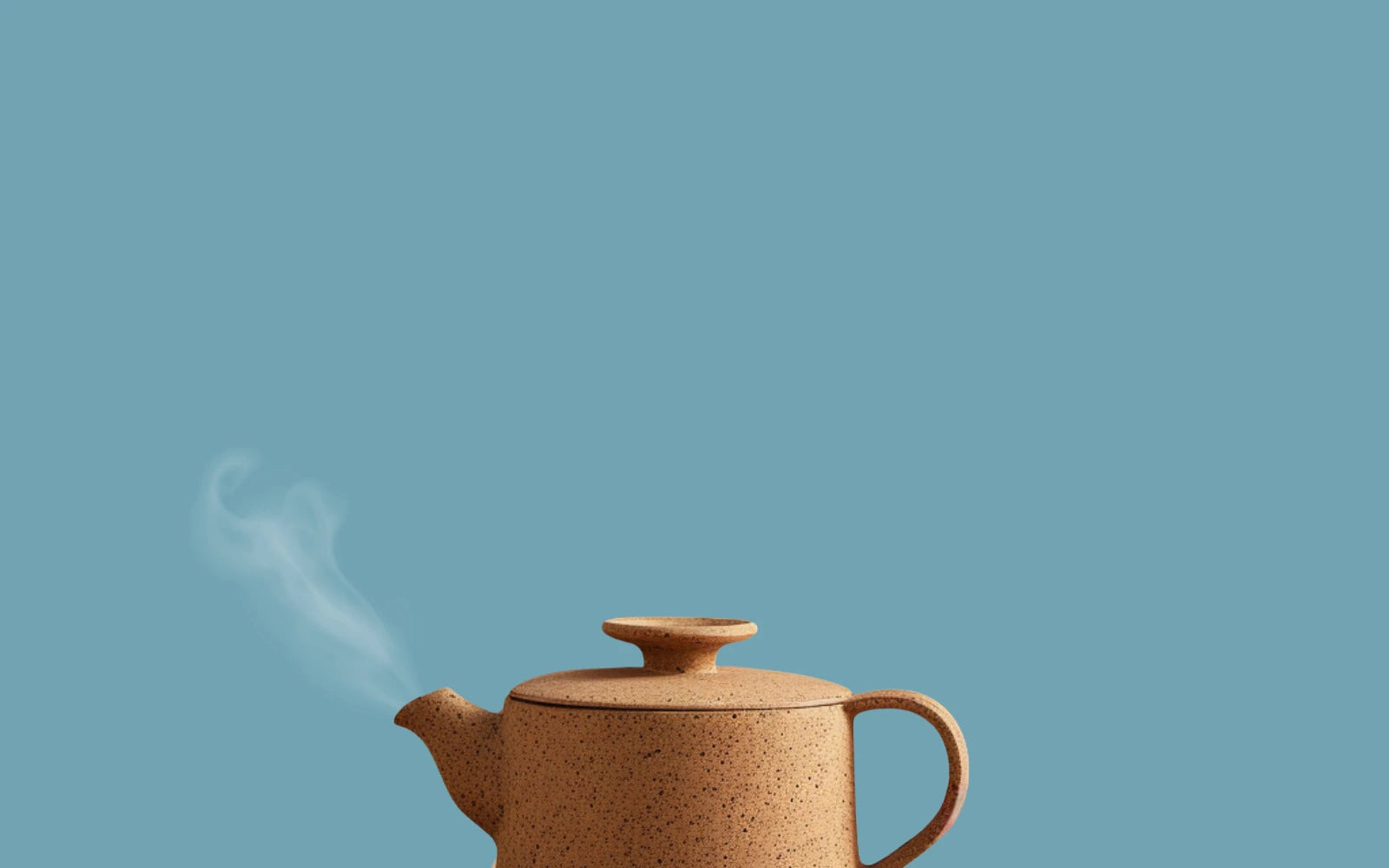 Image d'une théière moderne en grès de couleur beige pour le thé noir avec un fond bleu