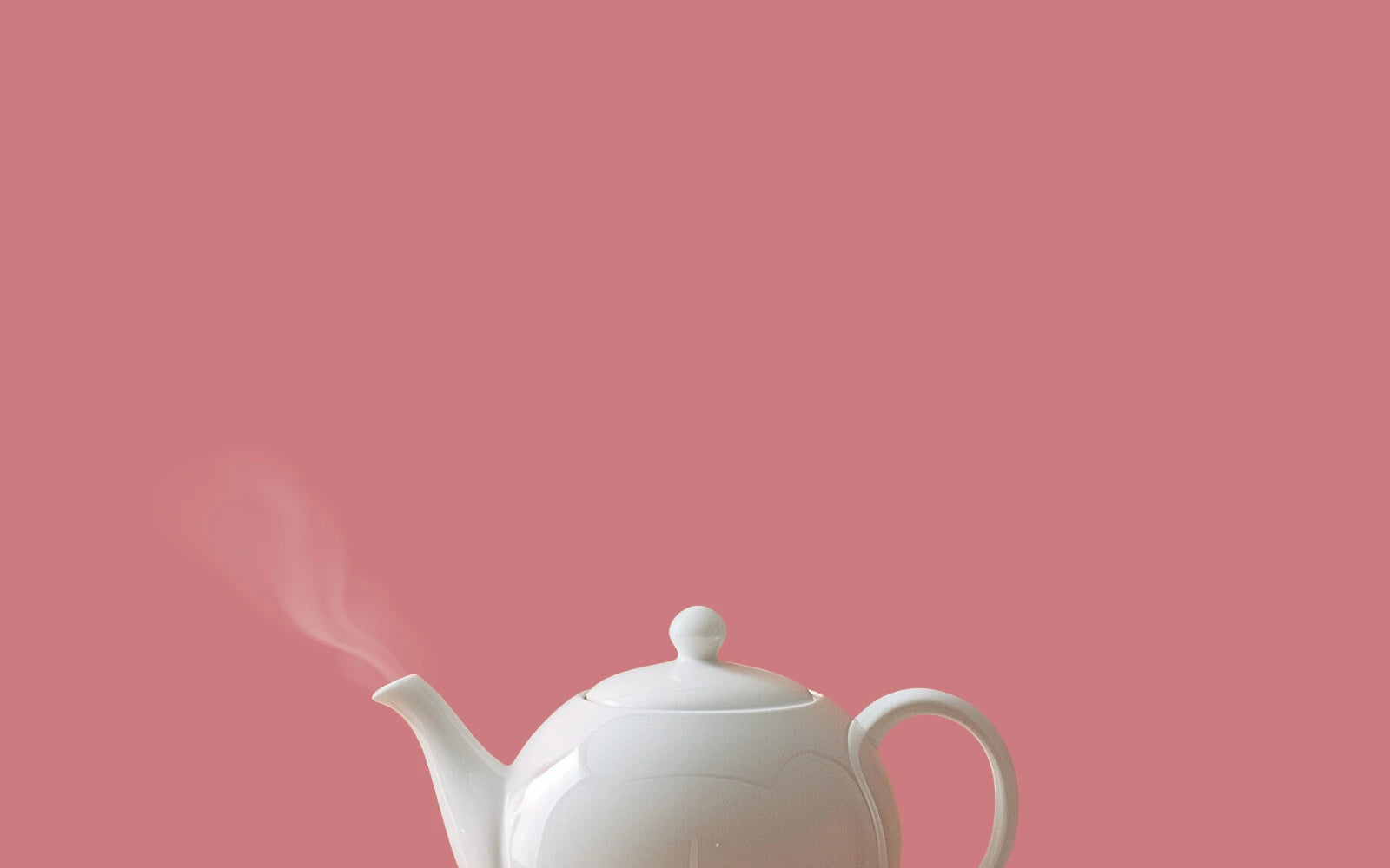 Image d'une théière classique en porcelaine de couleur blanche pour le thé vert avec un fond rose