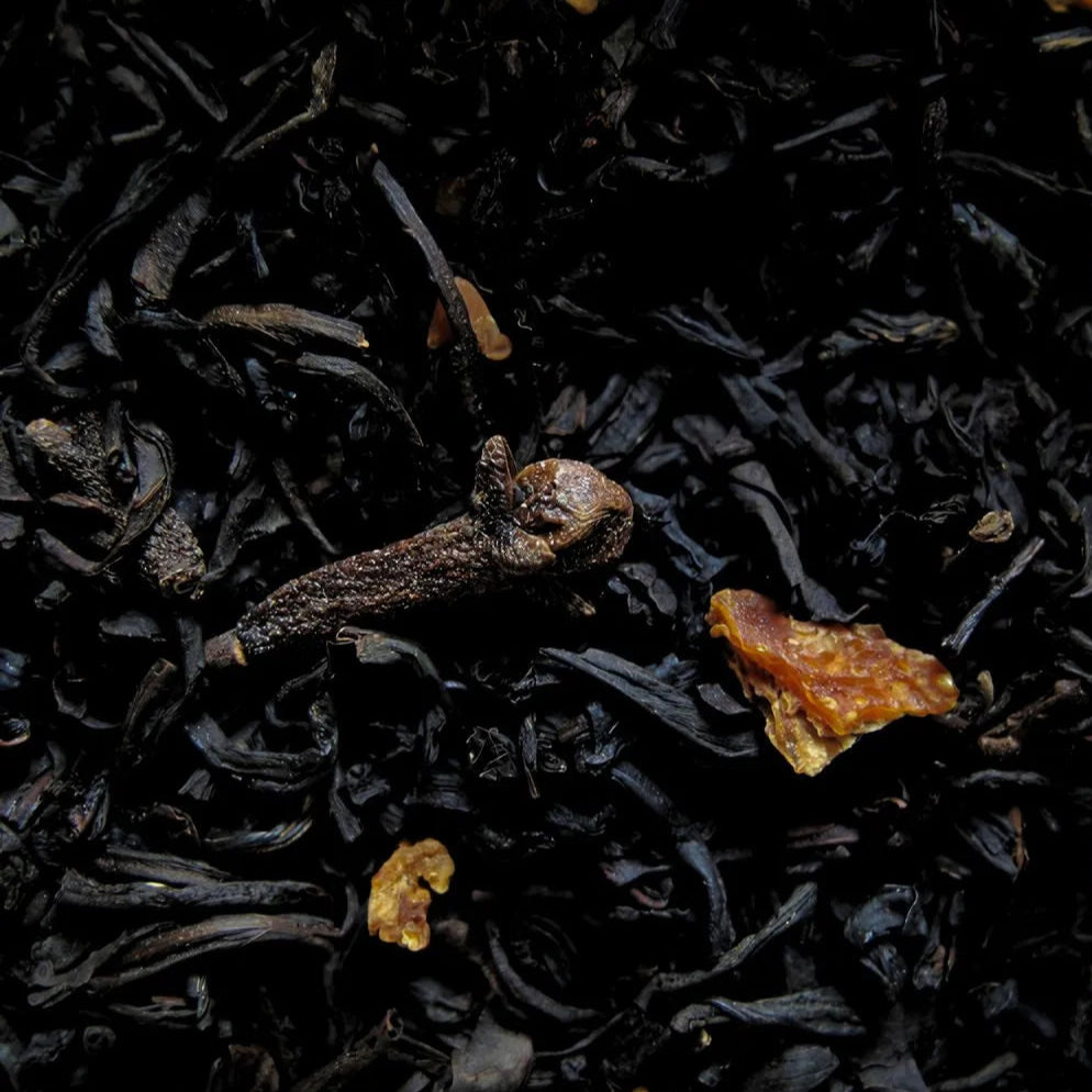 Zoom sur le thé noir et les clous de girole et les morceaux d'amande du thé de Noël